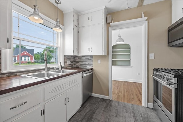 2500 D Ave NE, Cedar Rapids, IA 52402 - kitchen with stainless steel appliances, white cabinets, dark wood-type flooring, and decorative backsplash