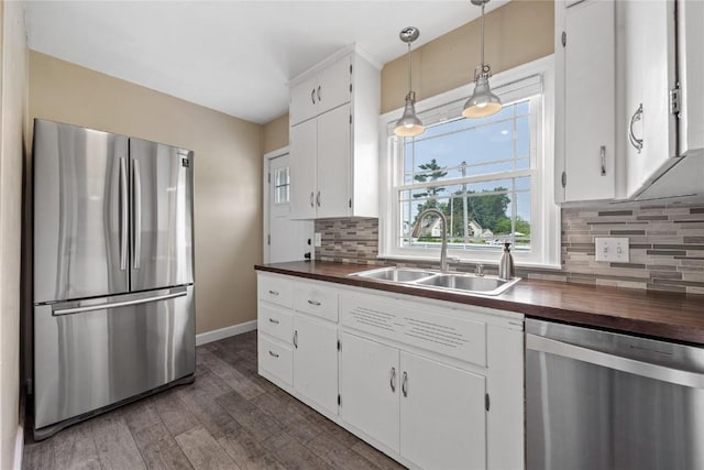 2500 D Ave NE, Cedar Rapids, IA 52402 - kitchen featuring appliances with stainless steel finishes, butcher block countertops, wood finished floors, backsplash, and white cabinets