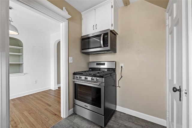 2500 D Ave NE, Cedar Rapids, IA 52402 - kitchen featuring appliances with stainless steel finishes, dark wood-style floors, arched walkways, and white cabinets