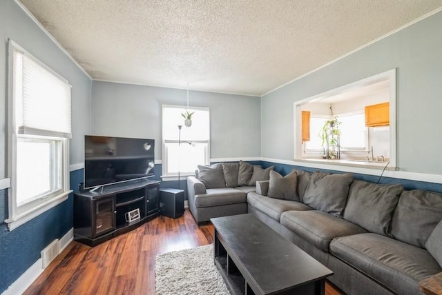 3825 Hart Ct, Cedar Rapids, IA 52402 - living area featuring a textured ceiling, healthy amount of natural light, dark wood-style floors, and crown molding