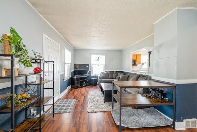 3825 Hart Ct, Cedar Rapids, IA 52402 - living area with ornamental molding, a textured ceiling, wood finished floors, and decorative columns