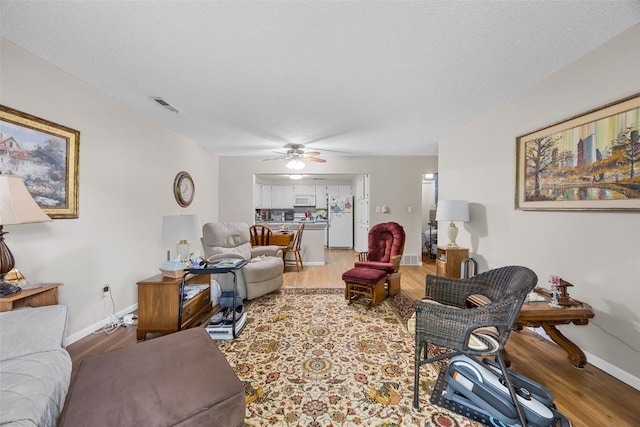 2131 1st Ave Unit 108, Cedar Rapids, IA 52402 - living area featuring light wood finished floors, ceiling fan, and a textured ceiling