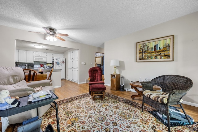 2131 1st Ave Unit 108, Cedar Rapids, IA 52402 - living area with light wood-style flooring, ceiling fan, and a textured ceiling
