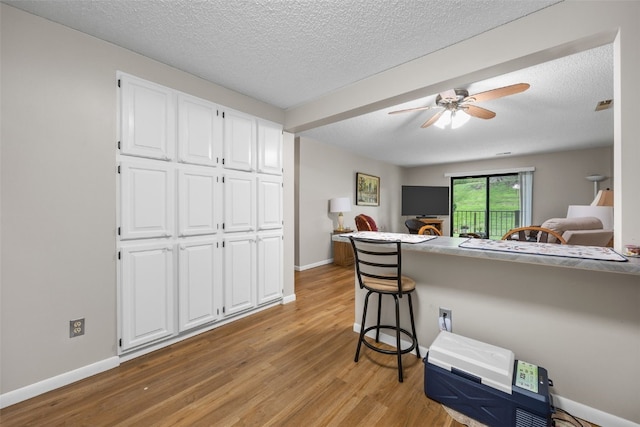 2131 1st Ave Unit 108, Cedar Rapids, IA 52402 - bedroom featuring light wood-style flooring, a textured ceiling, and a ceiling fan
