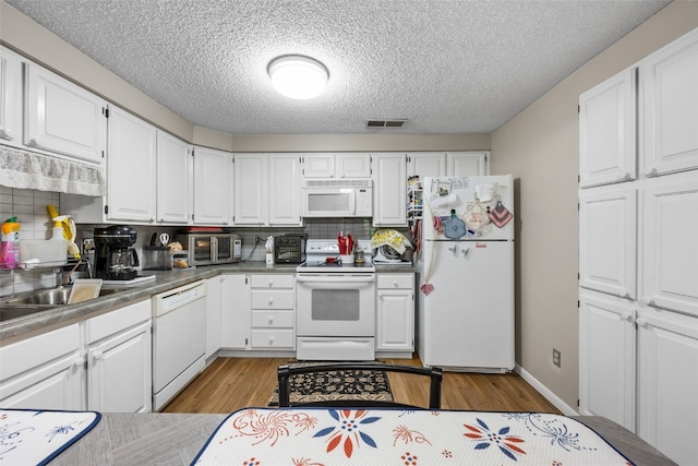 2131 1st Ave Unit 108, Cedar Rapids, IA 52402 - kitchen featuring white appliances, light wood finished floors, white cabinets, a textured ceiling, and decorative backsplash