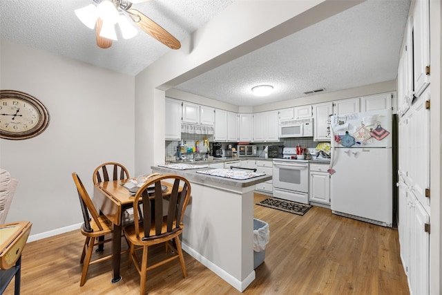 2131 1st Ave Unit 108, Cedar Rapids, IA 52402 - kitchen featuring white appliances, a peninsula, a textured ceiling, decorative backsplash, and light wood-type flooring