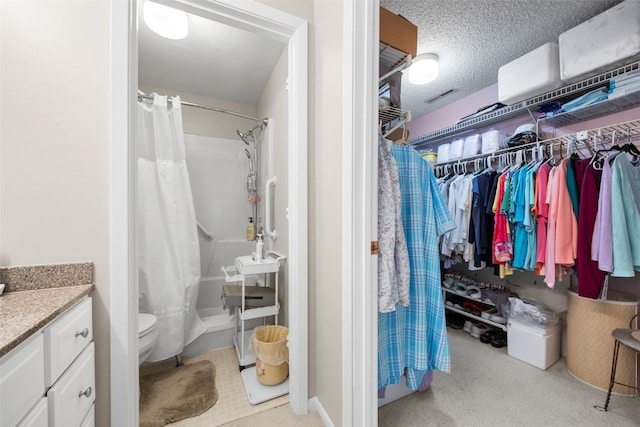 2131 1st Ave Unit 108, Cedar Rapids, IA 52402 - full bathroom featuring vanity, shower / tub combo, a textured ceiling, and a walk in closet