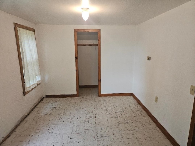 2142 310th Ave, Chelsea, IA 52215 - unfurnished bedroom with baseboards and a walk in closet