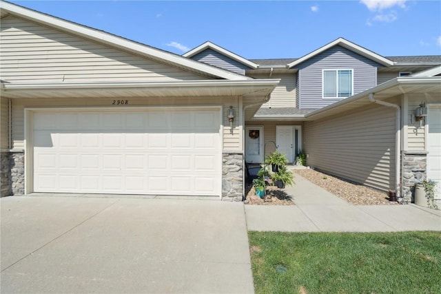 2908 Riviera St SW Unit B, Cedar Rapids, IA 52404 - view of front of home with stone siding, a garage, and concrete driveway