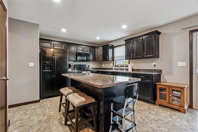 2908 Riviera St SW Unit B, Cedar Rapids, IA 52404 - kitchen featuring black appliances, a breakfast bar, a center island, dark stone counters, and recessed lighting