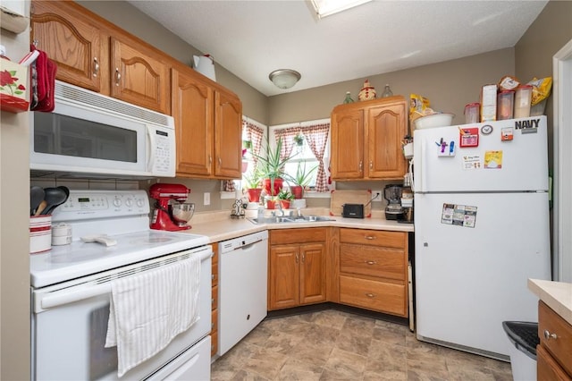 1305 E Ave, Vinton, IA 52349 - kitchen featuring white appliances, light countertops, stone finish floors, and brown cabinetry