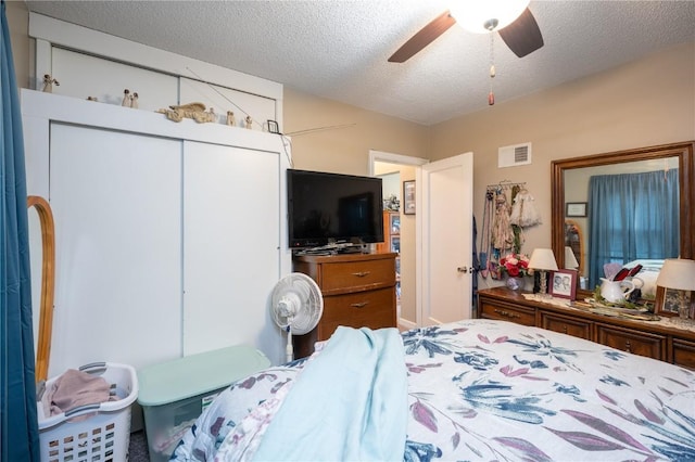 1305 E Ave, Vinton, IA 52349 - bedroom featuring a closet, a textured ceiling, and ceiling fan