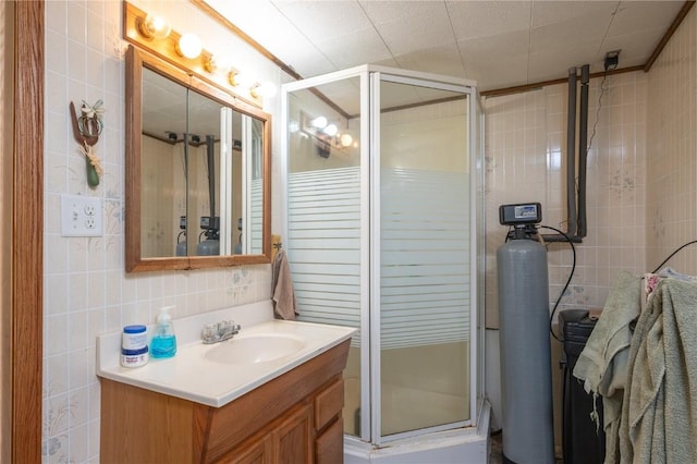 1305 E Ave, Vinton, IA 52349 - bathroom featuring tile walls, vanity, and a shower stall