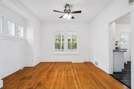 3107 E Ave NE, Cedar Rapids, IA 52402 - empty room with healthy amount of natural light, ceiling fan, and wood finished floors
