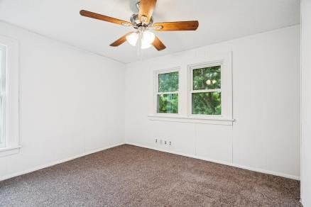 3107 E Ave NE, Cedar Rapids, IA 52402 - empty room featuring dark colored carpet and ceiling fan