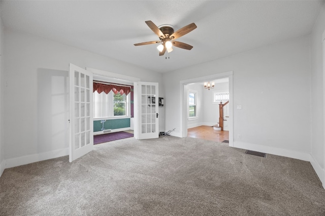899 Jackson Ave, Mechanicsville, IA 52306 - carpeted spare room with french doors, a ceiling fan, and a chandelier