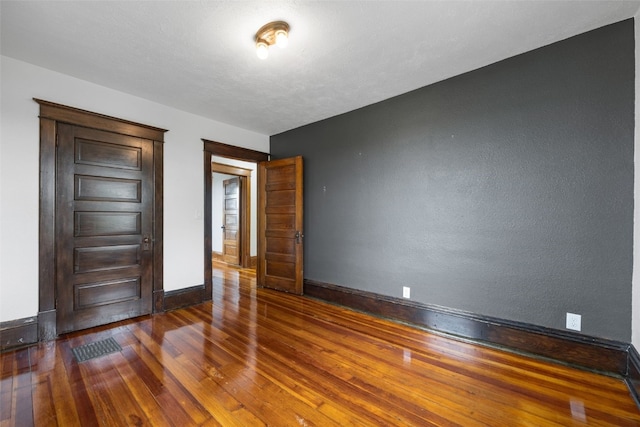 899 Jackson Ave, Mechanicsville, IA 52306 - unfurnished room with wood finished floors and a textured wall