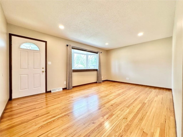 1125 W 10th Ave, Marion, IA 52302 - foyer entrance with light wood-type flooring, a textured ceiling, and recessed lighting