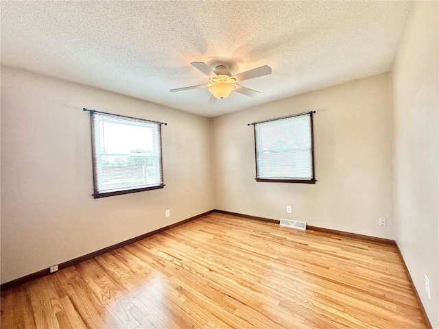 1125 W 10th Ave, Marion, IA 52302 - spare room featuring light wood-type flooring, a textured ceiling, and ceiling fan