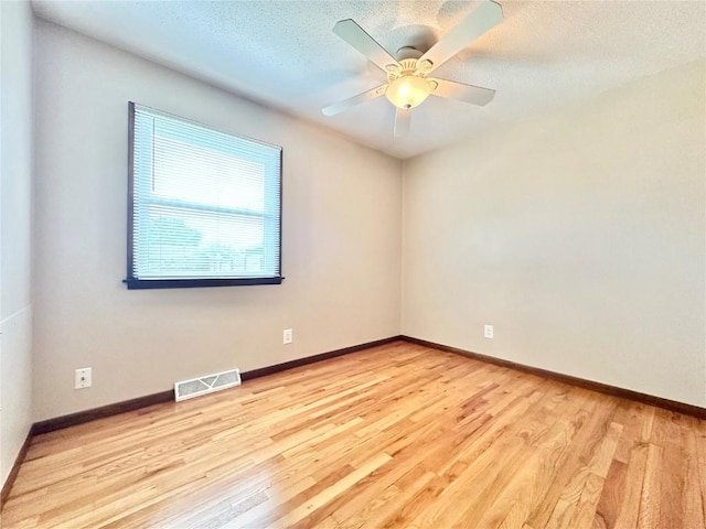 1125 W 10th Ave, Marion, IA 52302 - unfurnished room with wood finished floors, a ceiling fan, and a textured ceiling