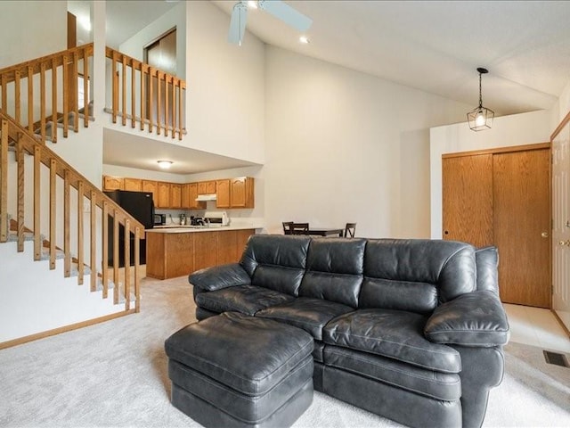 935 74th St NE Unit 5, Cedar Rapids, IA 52402 - living room featuring light colored carpet, high vaulted ceiling, stairs, and ceiling fan