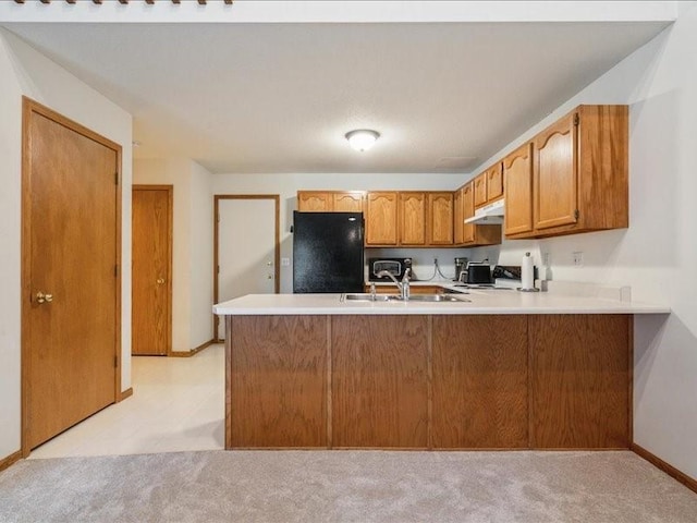 935 74th St NE Unit 5, Cedar Rapids, IA 52402 - kitchen with fridge, under cabinet range hood, a peninsula, and light colored carpet