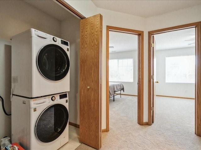 935 74th St NE Unit 5, Cedar Rapids, IA 52402 - laundry room featuring stacked washer / dryer and light colored carpet