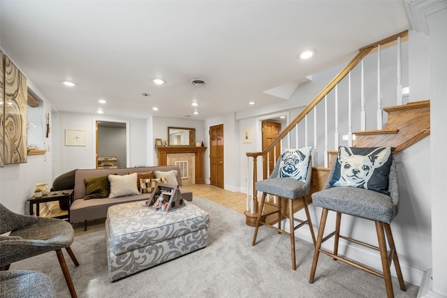2518 1st Ave NE, Cedar Rapids, IA 52402 - living area with recessed lighting, stairs, a tiled fireplace, light colored carpet, and light tile patterned floors