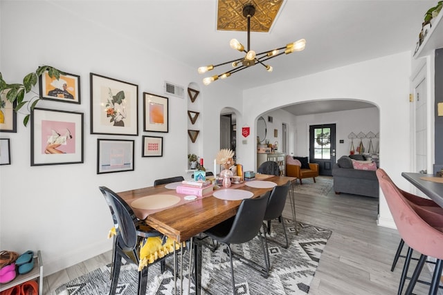 2518 1st Ave NE, Cedar Rapids, IA 52402 - dining area with arched walkways, a chandelier, and light wood-style flooring