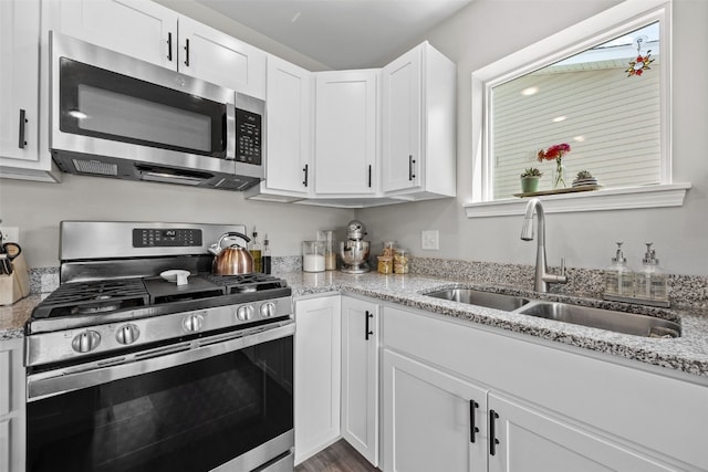 904 Hughes St, Coralville, IA 52241 - kitchen featuring stainless steel appliances, white cabinets, and light stone counters