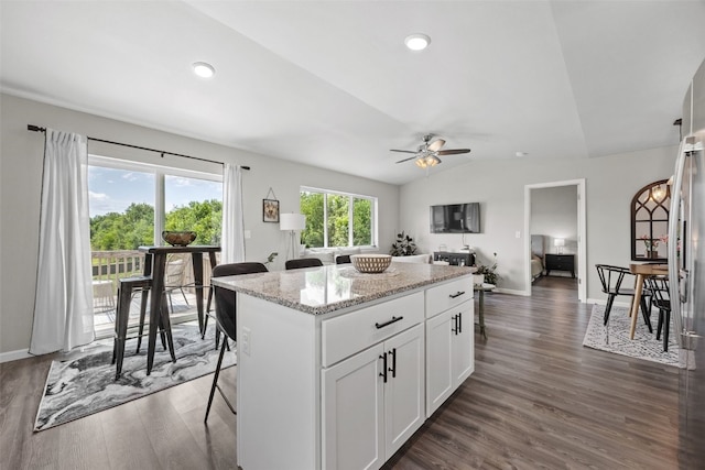 904 Hughes St, Coralville, IA 52241 - kitchen with a kitchen island, a ceiling fan, lofted ceiling, dark wood finished floors, and white cabinets