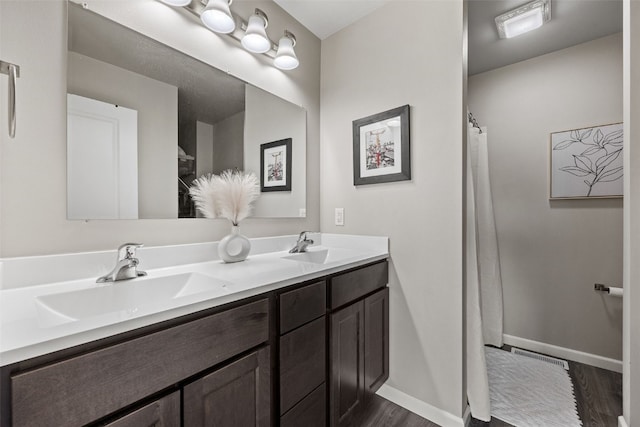 904 Hughes St, Coralville, IA 52241 - bathroom featuring wood finished floors and double vanity