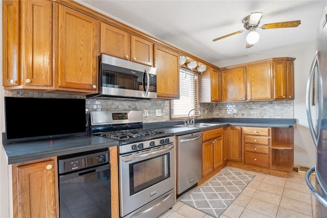 918 29th St NW, Cedar Rapids, IA 52405 - kitchen with appliances with stainless steel finishes, brown cabinetry, decorative backsplash, light tile patterned floors, and a ceiling fan