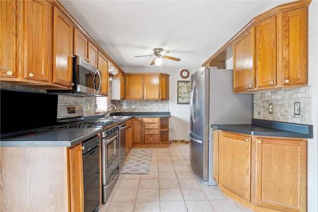 918 29th St NW, Cedar Rapids, IA 52405 - kitchen featuring stainless steel appliances, ceiling fan, decorative backsplash, and brown cabinetry