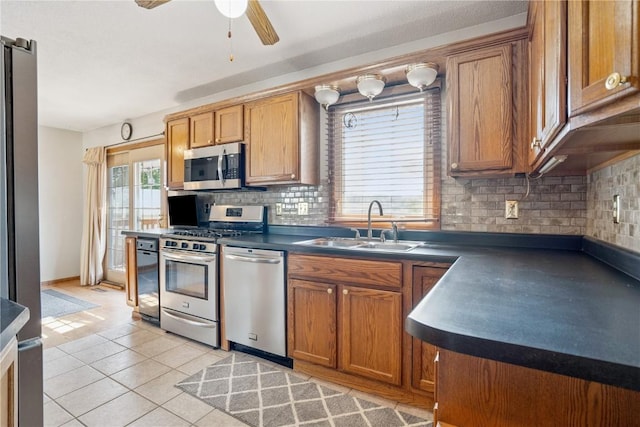 918 29th St NW, Cedar Rapids, IA 52405 - kitchen with stainless steel appliances, dark countertops, brown cabinets, and tasteful backsplash