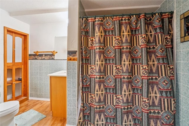 918 29th St NW, Cedar Rapids, IA 52405 - full bath with vanity, wood finished floors, tile walls, curtained shower, and a wainscoted wall