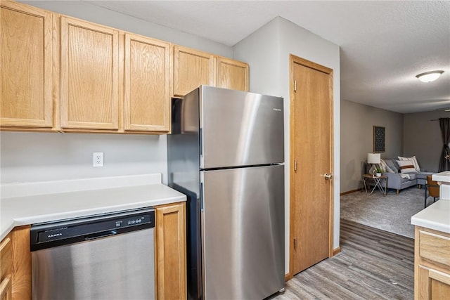780 Magnolia Ln Unit 4, Marion, IA 52302 - kitchen featuring appliances with stainless steel finishes, light brown cabinets, open floor plan, light countertops, and wood finished floors