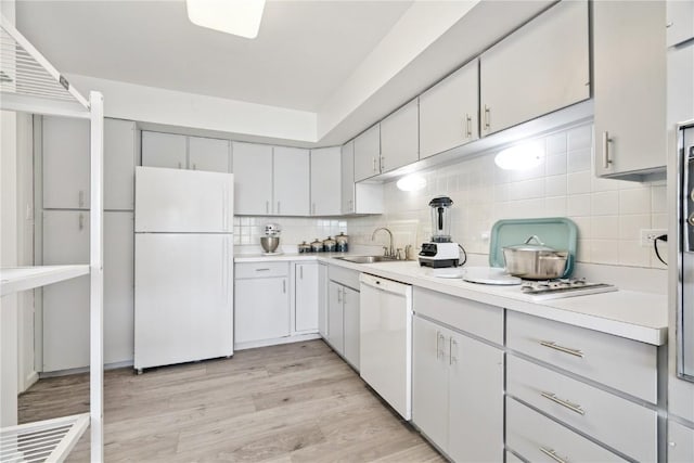 2222 1st Ave, Cedar Rapids, IA 52402 - kitchen featuring white appliances, backsplash, light countertops, and light wood-type flooring
