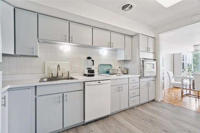 2222 1st Ave, Cedar Rapids, IA 52402 - kitchen with white appliances, light countertops, tasteful backsplash, and light wood-type flooring
