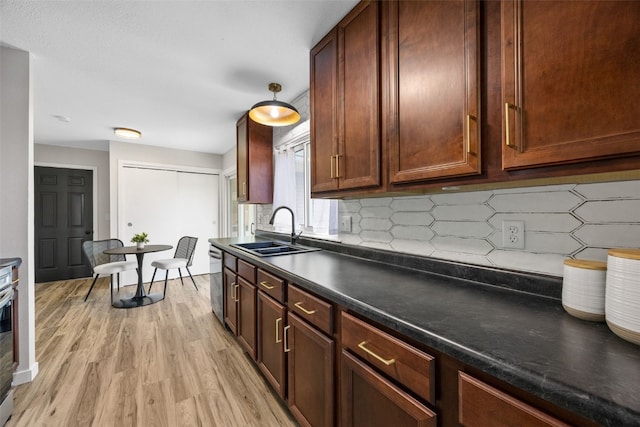 4812 Montclair Dr NW, Cedar Rapids, IA 52405 - kitchen featuring light wood finished floors, dark countertops, decorative backsplash, and stainless steel dishwasher