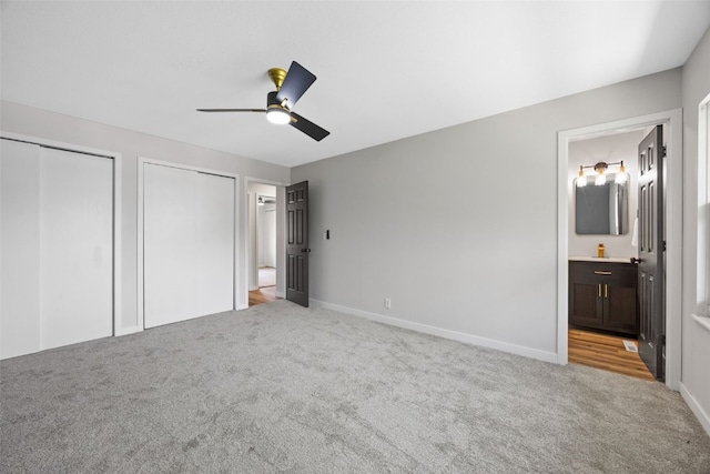 4812 Montclair Dr NW, Cedar Rapids, IA 52405 - unfurnished bedroom with carpet flooring, two closets, connected bathroom, and a ceiling fan