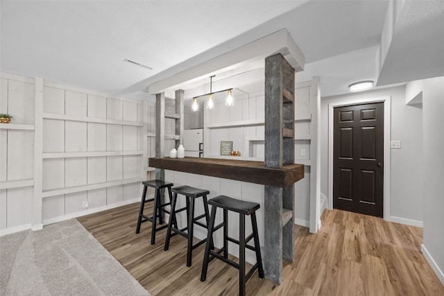 4812 Montclair Dr NW, Cedar Rapids, IA 52405 - indoor bar with wood finished floors, freestanding refrigerator, and built in shelves