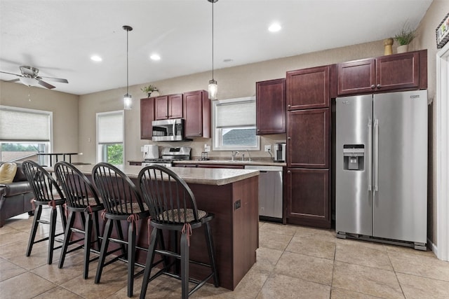 2816 Fruitland Blvd SW, Cedar Rapids, IA 52404 - kitchen featuring appliances with stainless steel finishes, a center island, a kitchen bar, a ceiling fan, and recessed lighting