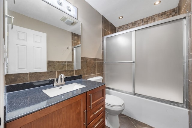 1125 Saint Andrews Dr, North Liberty, IA 52317 - full bathroom featuring vanity, bath / shower combo with glass door, tile patterned flooring, tile walls, and recessed lighting