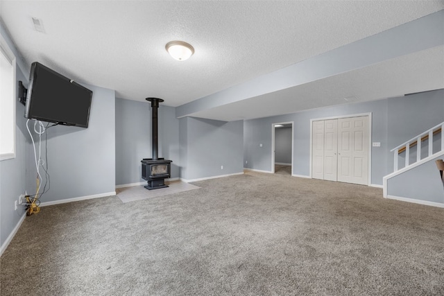 1125 Saint Andrews Dr, North Liberty, IA 52317 - unfurnished living room featuring carpet, stairs, a textured ceiling, and a wood stove