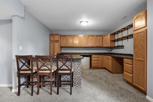 1125 Saint Andrews Dr, North Liberty, IA 52317 - kitchen with dishwasher, open shelves, carpet floors, dark countertops, and a textured ceiling