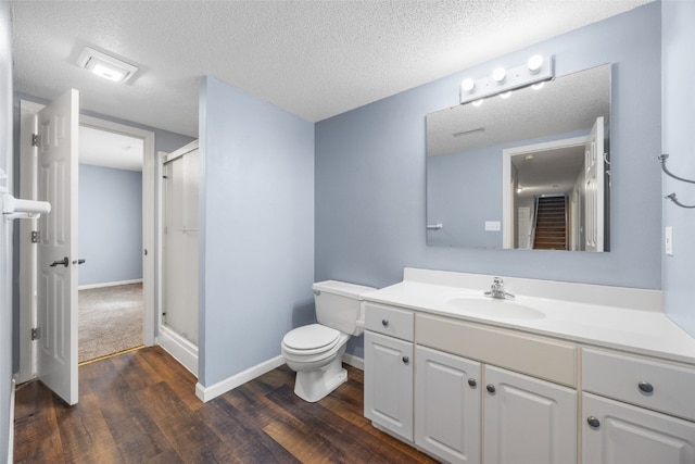 1125 Saint Andrews Dr, North Liberty, IA 52317 - bathroom featuring wood finished floors, a stall shower, vanity, and a textured ceiling