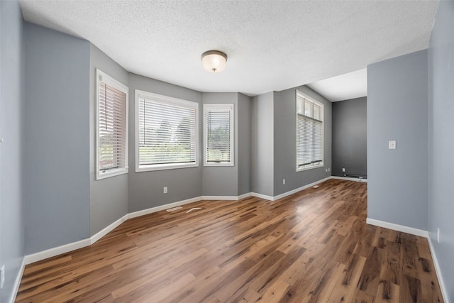 1125 Saint Andrews Dr, North Liberty, IA 52317 - unfurnished room with plenty of natural light, wood finished floors, and a textured ceiling