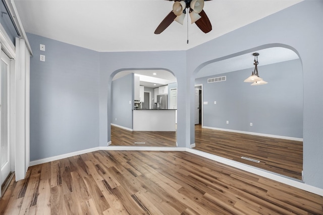 1125 Saint Andrews Dr, North Liberty, IA 52317 - unfurnished room with arched walkways, ceiling fan, and wood finished floors