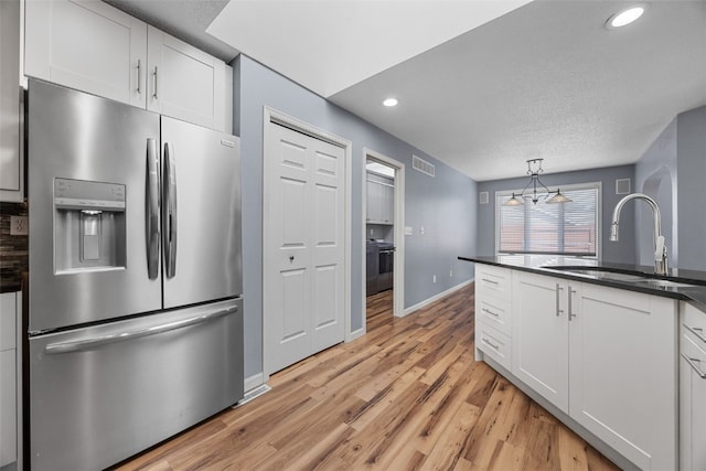 1125 Saint Andrews Dr, North Liberty, IA 52317 - kitchen featuring stainless steel fridge, dark countertops, recessed lighting, white cabinetry, and light wood finished floors